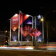 Reklamní plocha na štítu domu na Mendlově náměstí v Brně. Reklamní kampaň společnosti Vodafone. Noční snímek s dlouhým časem. Rozmazaná světla.